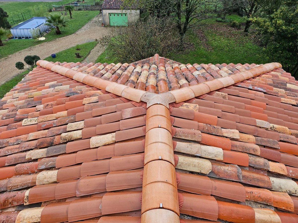 Aerial view of a terracotta clay tile roof with ridge cap and rural property