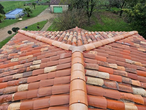 Aerial view of a terracotta clay tile roof with ridge cap